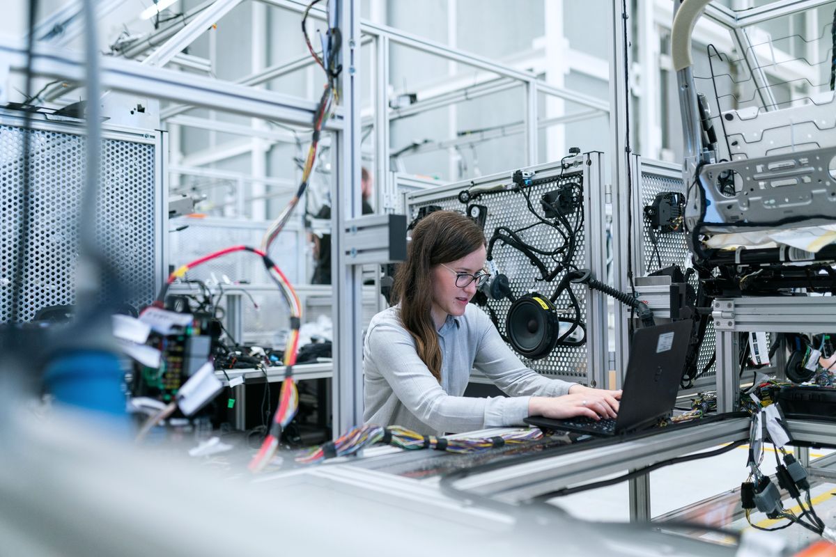 Engineer working on a laptop among technical equipment in a laboratory.
